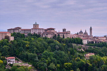 Fototapeta na wymiar The profile view of the beautiful medieval upper city of Bergamo with the Po Valley in the background at sunrise
