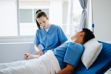 Fototapeta premium Friendly Female Head Nurse Making Rounds does Checkup on Patient Resting in Bed. She Checks tablet while Man Fully Recovering after Successful Surgery in hospital..