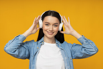 A young woman in a denim shirt and headphones