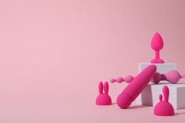 Composition of pink sex toys with cubes on a pink background