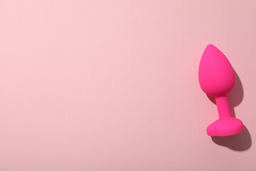 Pink butt plug on pink background with space for text