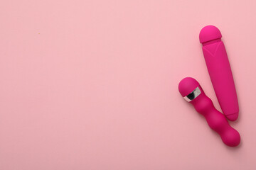 Two pink vibrators on a pink background, place for text