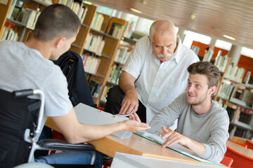 man with student in wheelchair in the library
