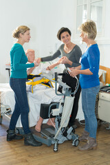 Fototapeta na wymiar nurses practicing procedure to lift disabled patient from bed