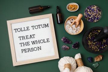 Letter board with text Tolle totum meaning treat the whole person in latin. Naturopatical principle. Botanical blends, herbs, essencial oils for naturopathy. Natural remedy, herbal medicine concept