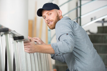 worker in uniform carry the ladder