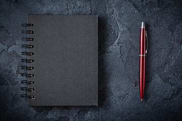 Red Ballpoint Pen And Black Notepad