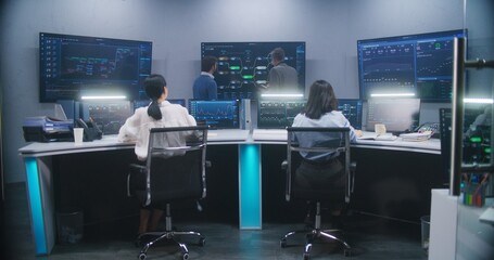 Female software engineer sits at computer with displayed blockchain network and surveillance maps....
