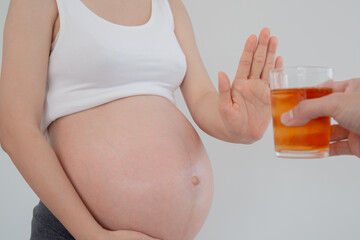 Pregnant woman rejecting and say no alcohol or liqueur during pregnancy, stop gesture, refuses , confuse, prevent disabilities or disorders in baby, healthy of life and caring about health of baby