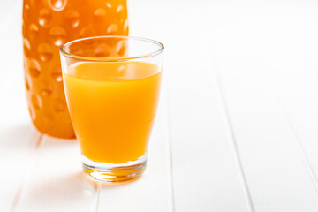 A glass of fruit juice. Orange  juice on white table.
