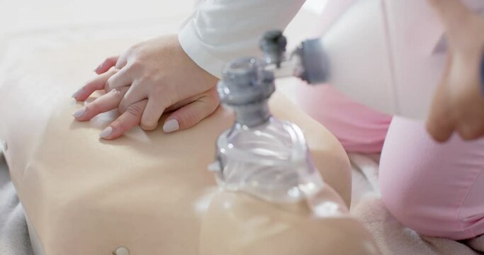 Diverse trainee doctors having training in emergency cpr procedure using dummy, slow motion