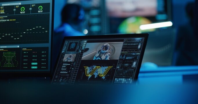 Successful space rocket launch for crewed mission displayed on digital tablet and PC monitor. Team of flight control employees monitor space mission on computer and big screen in command center.