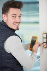 electrician checking socket with multimeter
