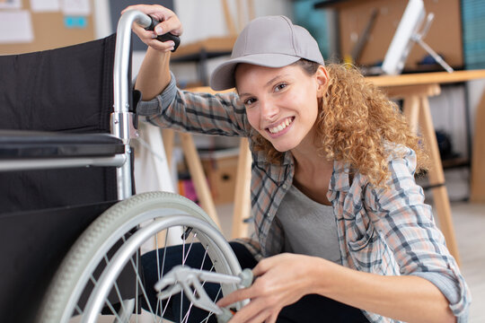 woman is repairing a wheelchair in garage