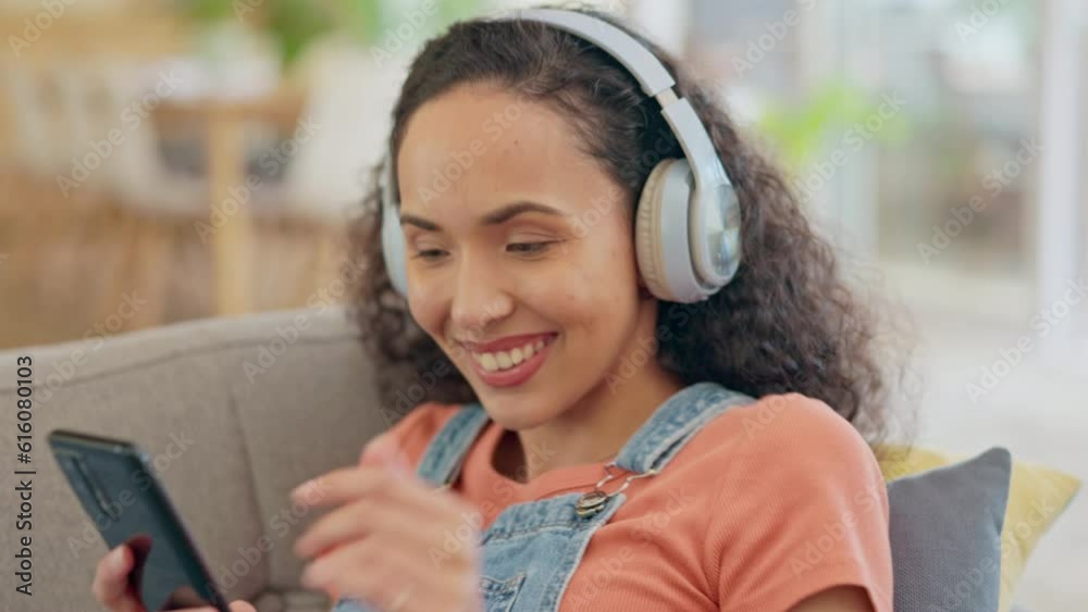 Wall mural Woman, phone and headphones on couch listening, audio streaming and dancing for mental health and home break. Relax, sofa and young person with gen z music, electronics and mobile chat in living room