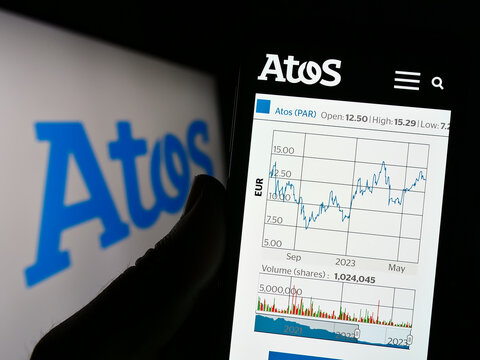 Stuttgart, Germany - 06-17-2023: Person holding cellphone with website of French information technology company Atos SE on screen with logo. Focus on center of phone display.