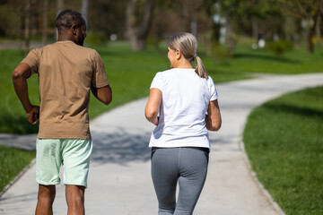 Mature couple jogging in the park together