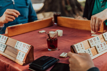 A group of men drink traditional Turkish tea and play a Turkish game called Okey