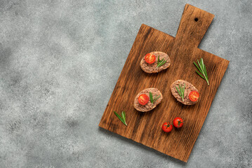 Toast with liver pate in a wooden board, gray concrete background. Open sandwich with liver pate....