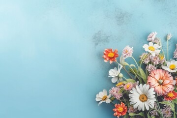 Small beautiful flower blossoms on blue pastel background with copy space. Floral pattern layout with a lots of place for adding text