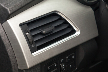 A close up of a ventilation nozzle in a base budget car