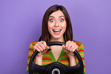 Fototapeta na wymiar Portrait of overjoyed lovely stylish lady have fun drive own fast car enjoy rejoice travel isolated on purple color background