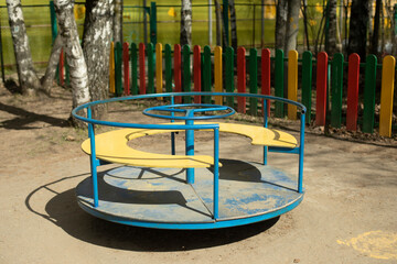 Fototapeta na wymiar Carousel on playground. Empty playground. Attraction for toddlers.