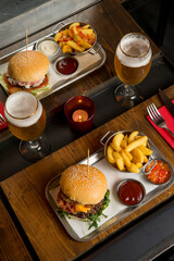 hamburger with potatoes and beer over restaurant table