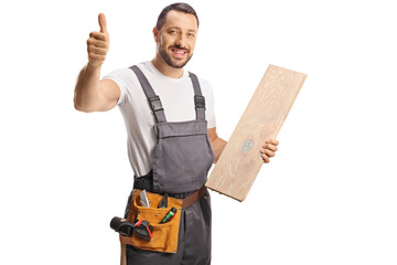 Carpenter holding a wooden floor beam and gesturing a thumb up sign