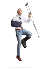 Happy man recovering from an injury and jumping with a crutch