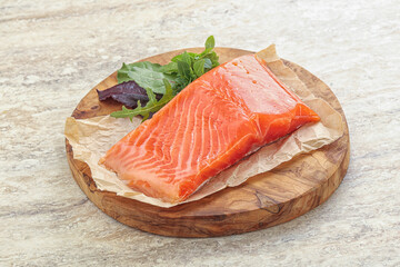 Raw salmon fillet over board