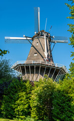 Historical dutch windmill De Bloem from 1768 in Amsterdam West on a sunny summer day - obrazy, fototapety, plakaty