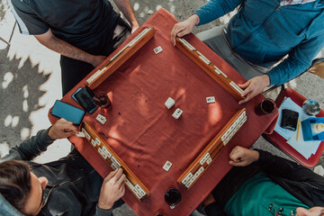 A group of men drink traditional Turkish tea and play a Turkish game called Okey