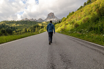 man walking in the road to the mountains