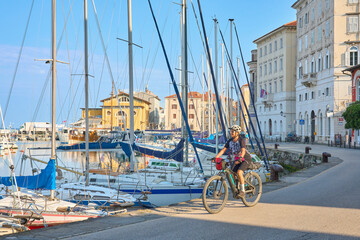 beautiful senior woman cycling in downtown Piran at the Adriatic sea in Slovenia, Europe