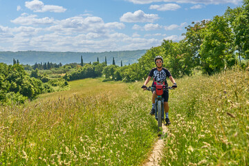 Naklejka na ściany i meble nice active senior woman on a bike tour with their electric mountain bikes in the Karst Mountains of Slovenia near Solkan