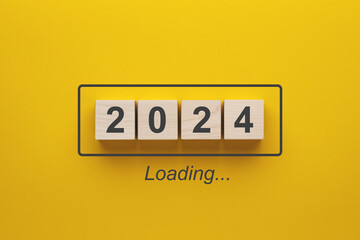 2024 new year loading. Wooden cubes with 2024 on a yellow background.