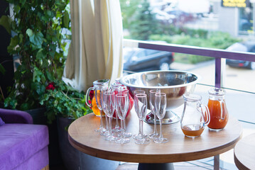 Restaurant table setting up with tableware. Wine glasses, ice cubes and carafes of drinks. Concept of hospitality and catering. Juice on a summer day