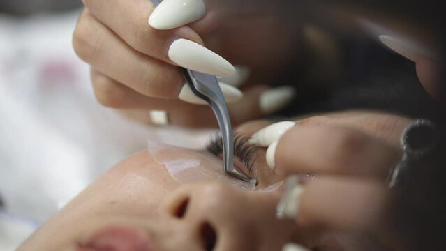 Unrecognizable Woman Eye Close-Up On Eyelash Extension Procedure.  