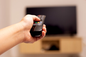 Hand holding TV remote control