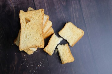 Tea Time Snack. Healthy Wheat rusk served with Indian hot masala tea and milk jug over black background. also known as Mumbai cutting chai. with Copy space. Crunchy rusk or toast.