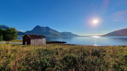 pittoresque hut in beautiful scenery at Norwegian fjord with mountains in the background