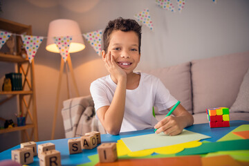 Photo of adorable boy sitting desk doing task on weekend educational montessori courses on cozy domestic apartment © deagreez
