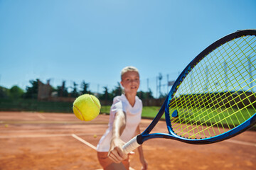 Close up photo of a young girl showing professional tennis skills in a competitive match on a sunny...