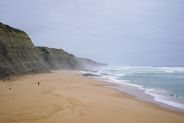 Praia do Magoito, Sintra, Portugal - March 2023: View of the ocean, rocks, sand and waves on the beach. Atlantic Ocean.