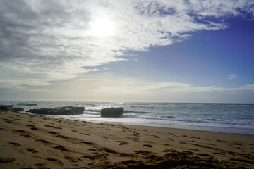 Praia do Magoito, Sintra, Portugal - March 2023: View of the ocean, rocks, sand and waves on the beach. Atlantic Ocean.