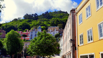 Fototapeta na wymiar herrlicher Blick auf Berg von Sintra mit Häusern bei Lissabon mit weißen Wolken über grünem Wald