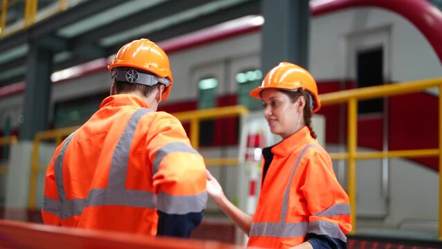 Railway Transportation Inspector With Engineer Checking and Maintaining part of train in station.