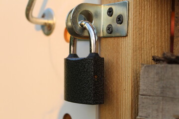 metal padlock on the door of a wooden shed
