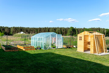 A wooden garden shed under construction standing on a concrete foundation in the garden, visible...